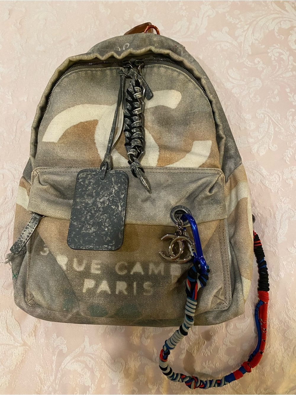 CHANEL Faded Beige Canvas Backpack with Multicolor Strap and Silver-Tone Charm